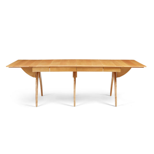 A mid-century modern wooden dining table with a butterfly drop-leaf design, shown in an Amber finish with the leaves closed.